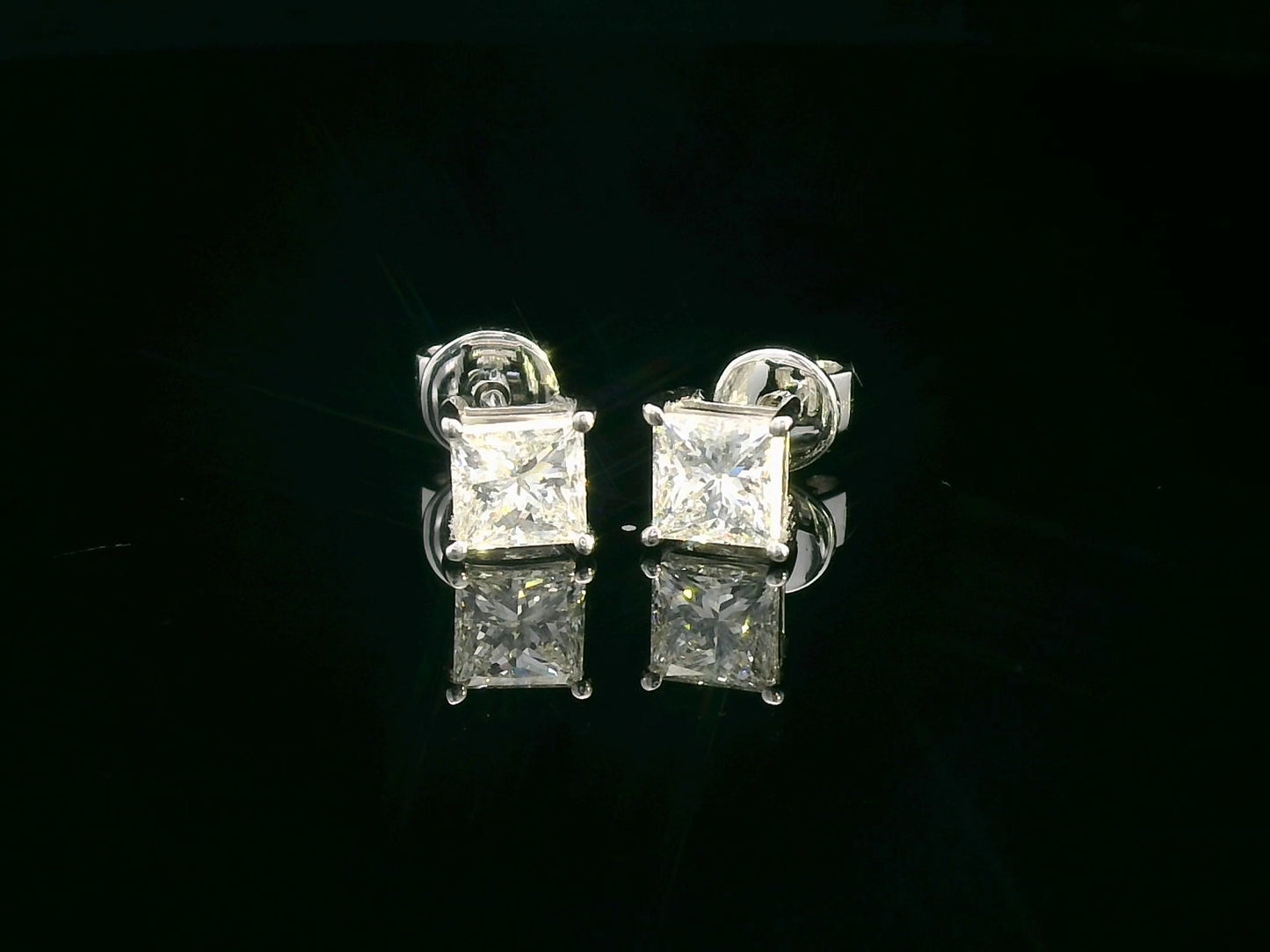 Princess-cut diamond solitaire stud earrings in 18K white gold, 1.01 carat total, GIA certified.