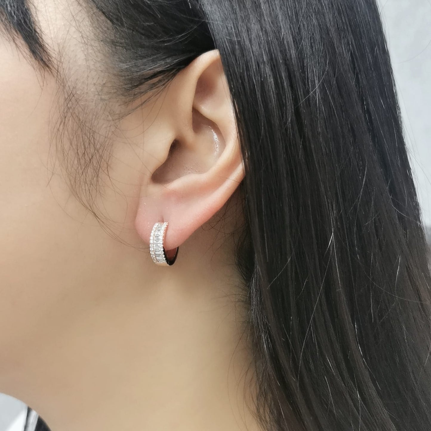 18K rose gold huggie hoop earrings with 0.58 CT round and baguette diamonds, featuring a secure and stylish design for a luxurious sparkle.