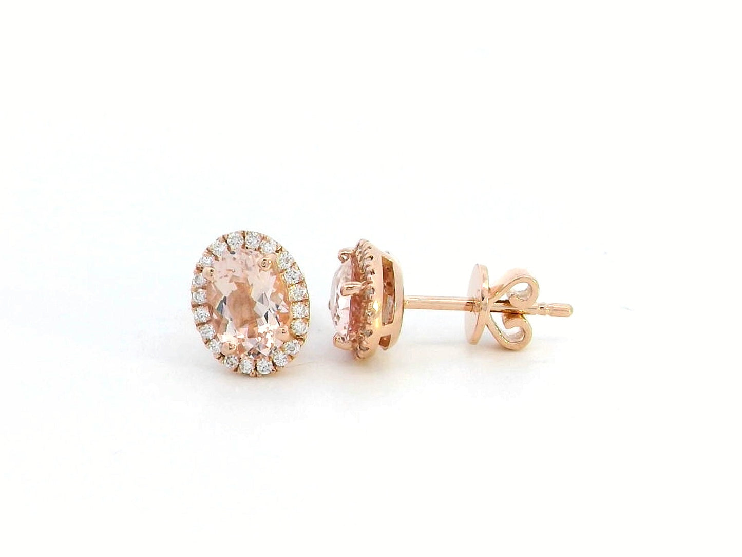 Elegant 18K gold stud earrings featuring 1.40 carats of oval-cut morganite gemstones, each encircled by a halo of 0.19 carats of round diamonds, secured with a push-back closure for timeless sophistication.
