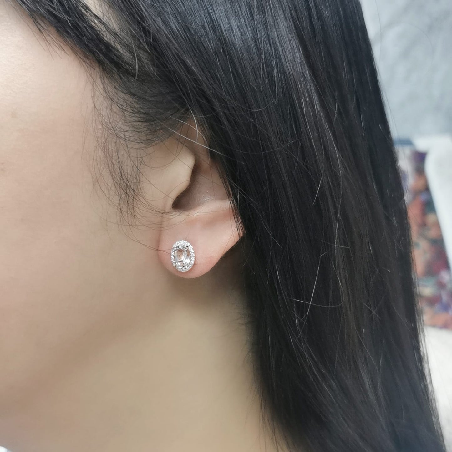Elegant 18K gold stud earrings featuring 1.40 carats of oval-cut morganite gemstones, each encircled by a halo of 0.19 carats of round diamonds, secured with a push-back closure for timeless sophistication.