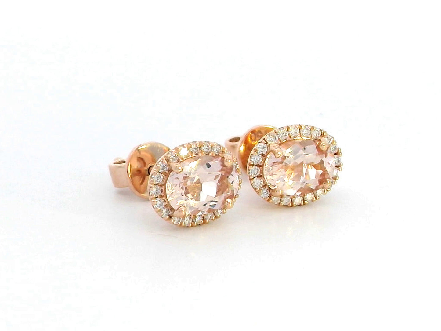 Elegant 18K gold stud earrings featuring 1.40 carats of oval-cut morganite gemstones, each encircled by a halo of 0.19 carats of round diamonds, secured with a push-back closure for timeless sophistication.
