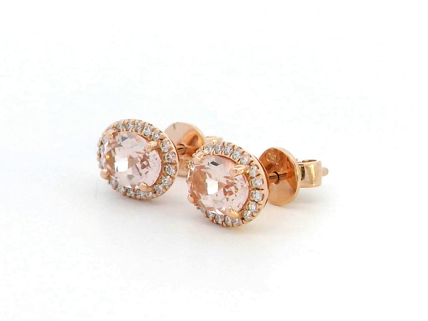 Elegant 18K gold stud earrings featuring 1.40 carats of oval-cut morganite gemstones, each encircled by a halo of 0.19 carats of round diamonds, secured with a push-back closure for timeless sophistication.