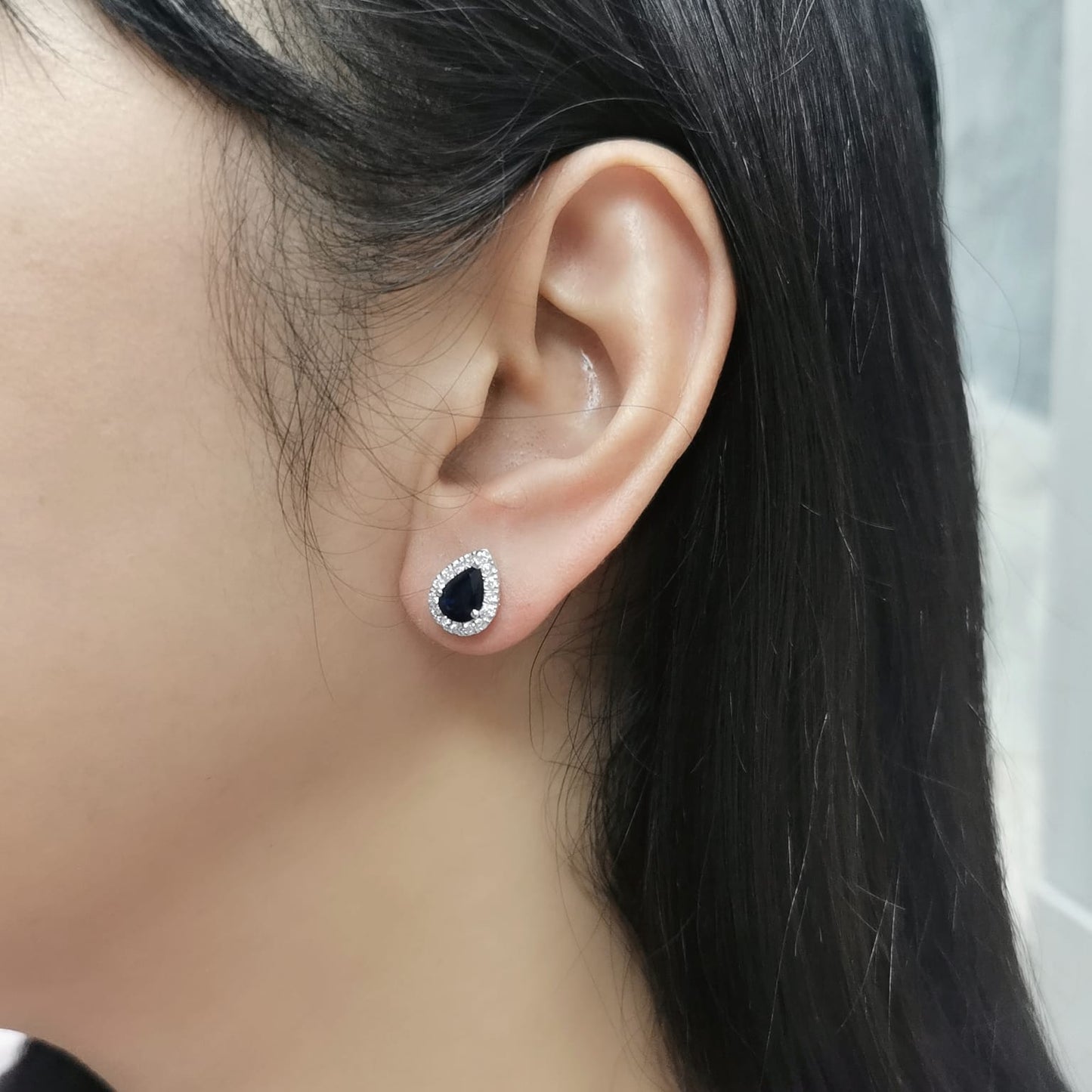 18K white gold pear-shaped blue sapphire and diamond halo stud earrings featuring 1.92 carats of blue sapphires and 0.38 carats of diamonds.
