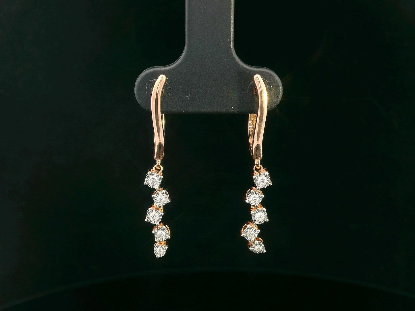 18K gold diamond drop earrings with huggie hoop closure and dangling round-cut diamonds, minimalist and elegant design.