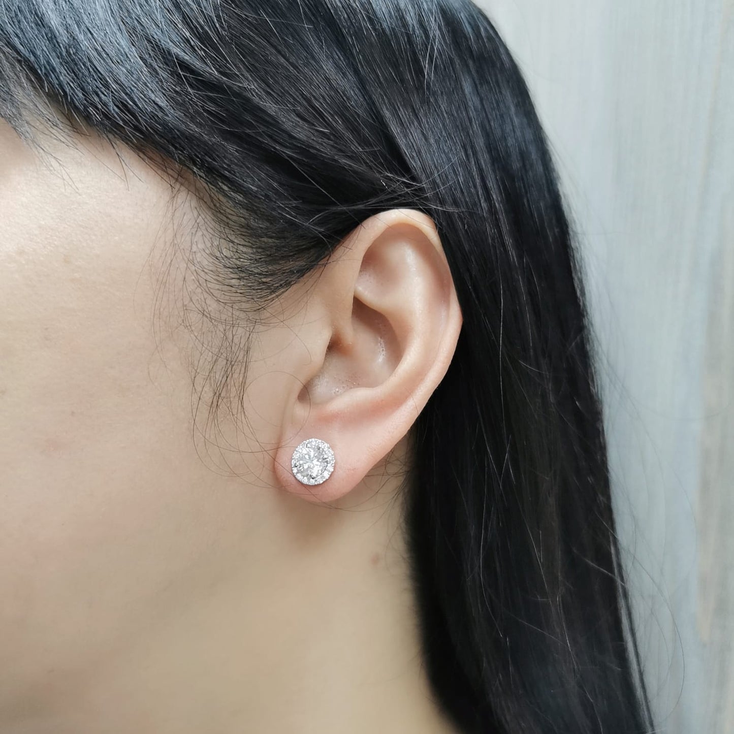 18K gold diamond halo stud earrings featuring two 1.00-carat round-cut center diamonds with a 0.33-carat halo – elegant and timeless bridal jewelry.