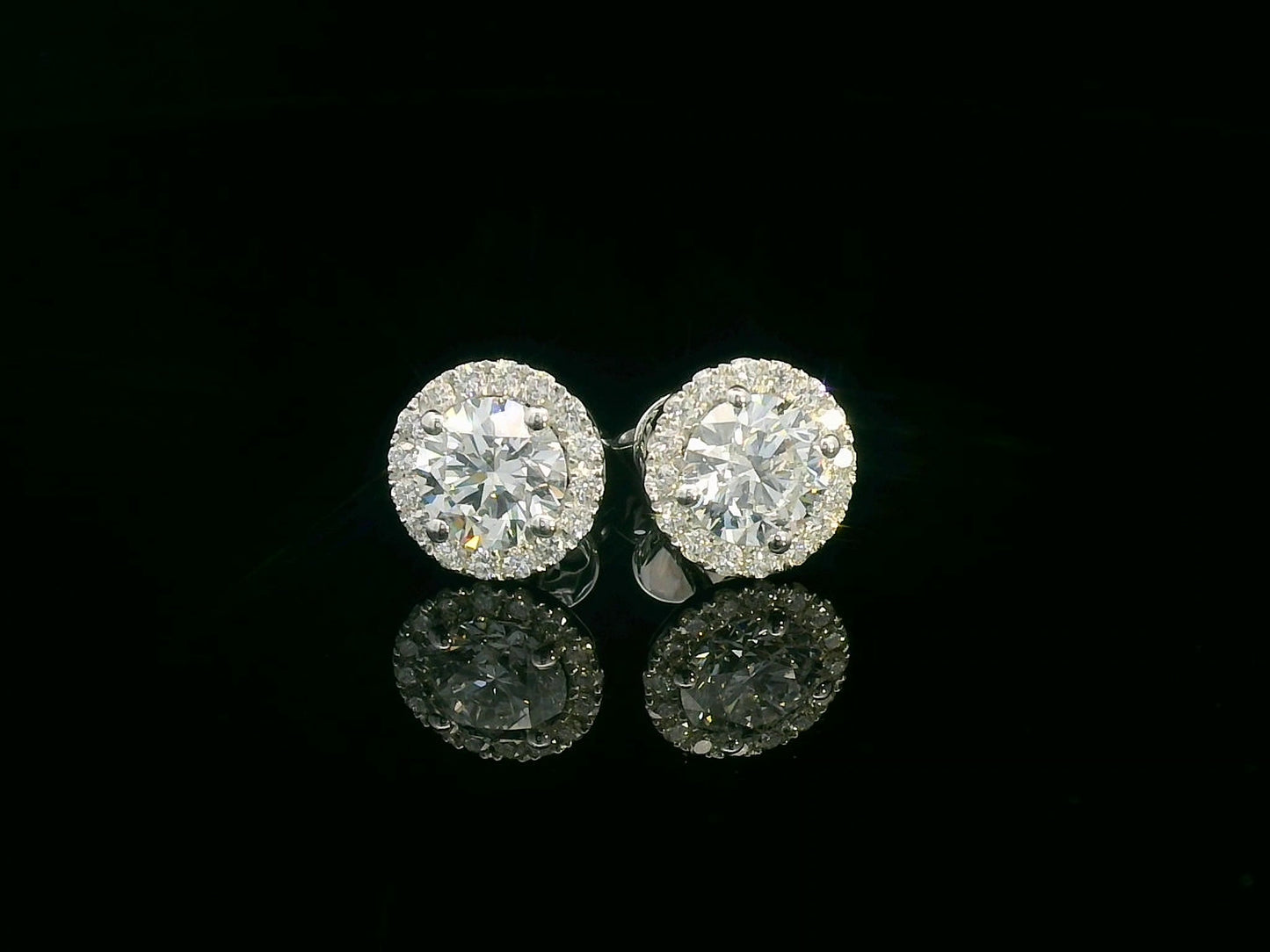 18K gold diamond halo stud earrings featuring two 1.00-carat round-cut center diamonds with a 0.33-carat halo – elegant and timeless bridal jewelry.