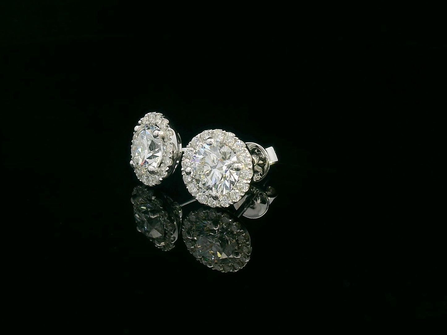 18K gold diamond halo stud earrings featuring two 1.00-carat round-cut center diamonds with a 0.33-carat halo – elegant and timeless bridal jewelry.