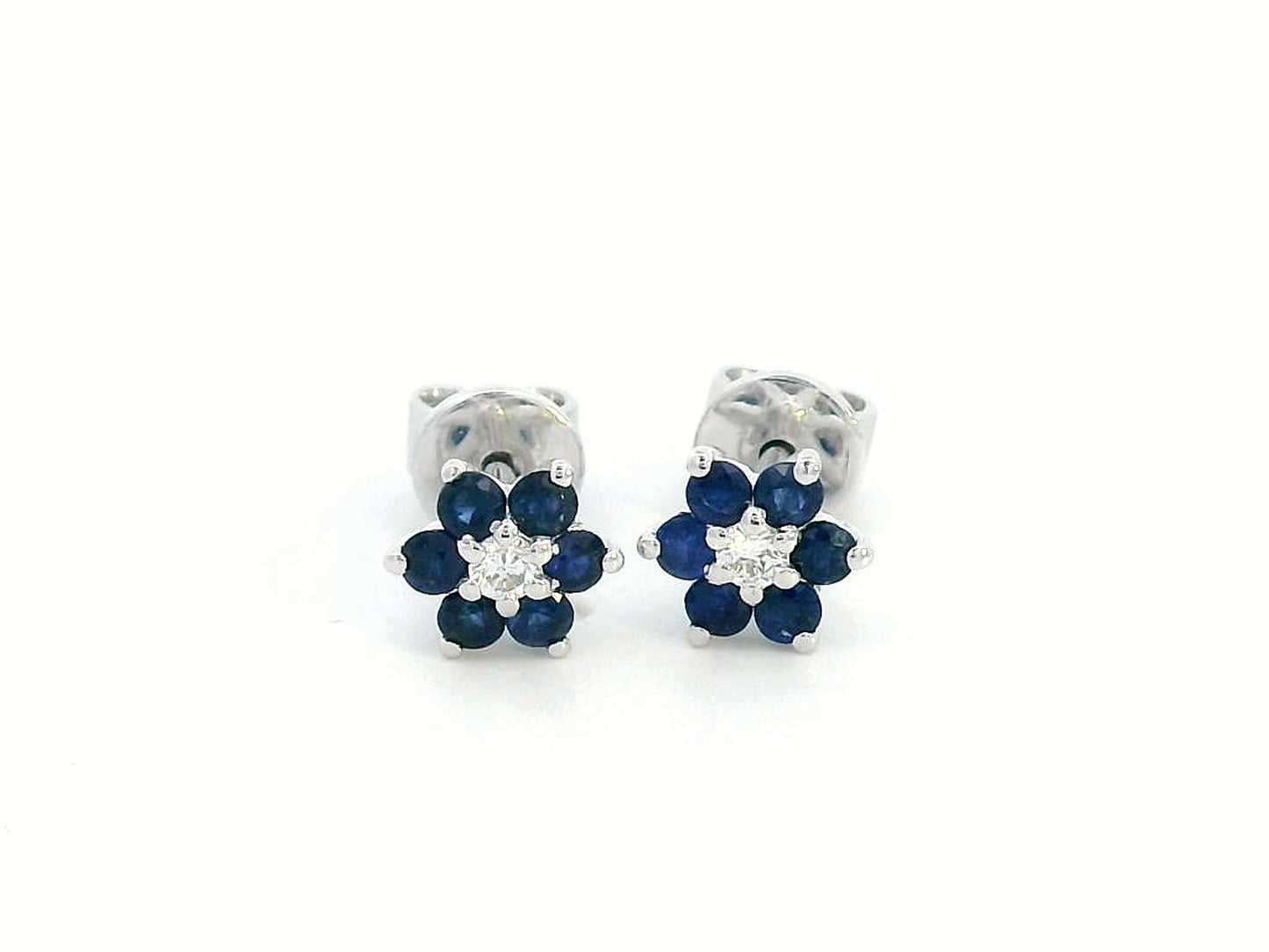Elegant 18K gold sapphire and diamond flower stud earrings featuring 0.33 carats of blue sapphires and 0.05 carats of diamonds. A timeless floral design.