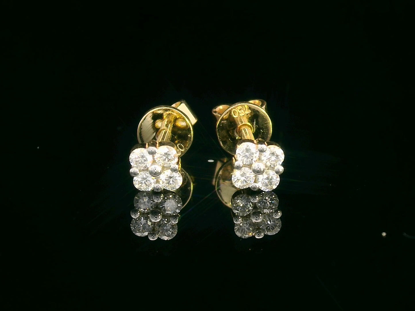 18K gold floral diamond stud earrings with round-cut diamonds, delicate flower design.