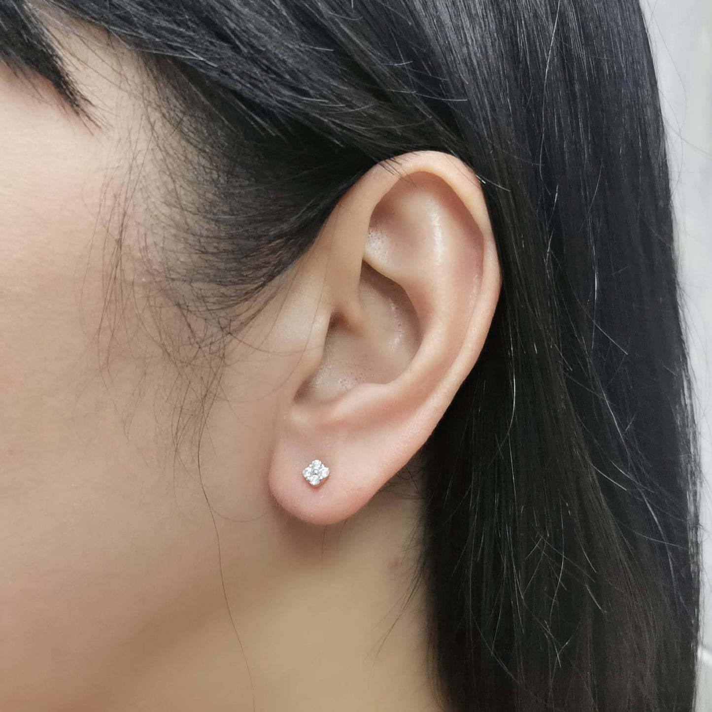 18K gold floral diamond stud earrings with round-cut diamonds, delicate flower design.