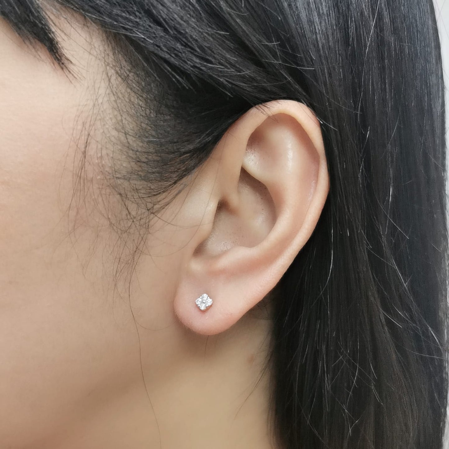 18K gold floral diamond stud earrings with round-cut diamonds, delicate flower design.