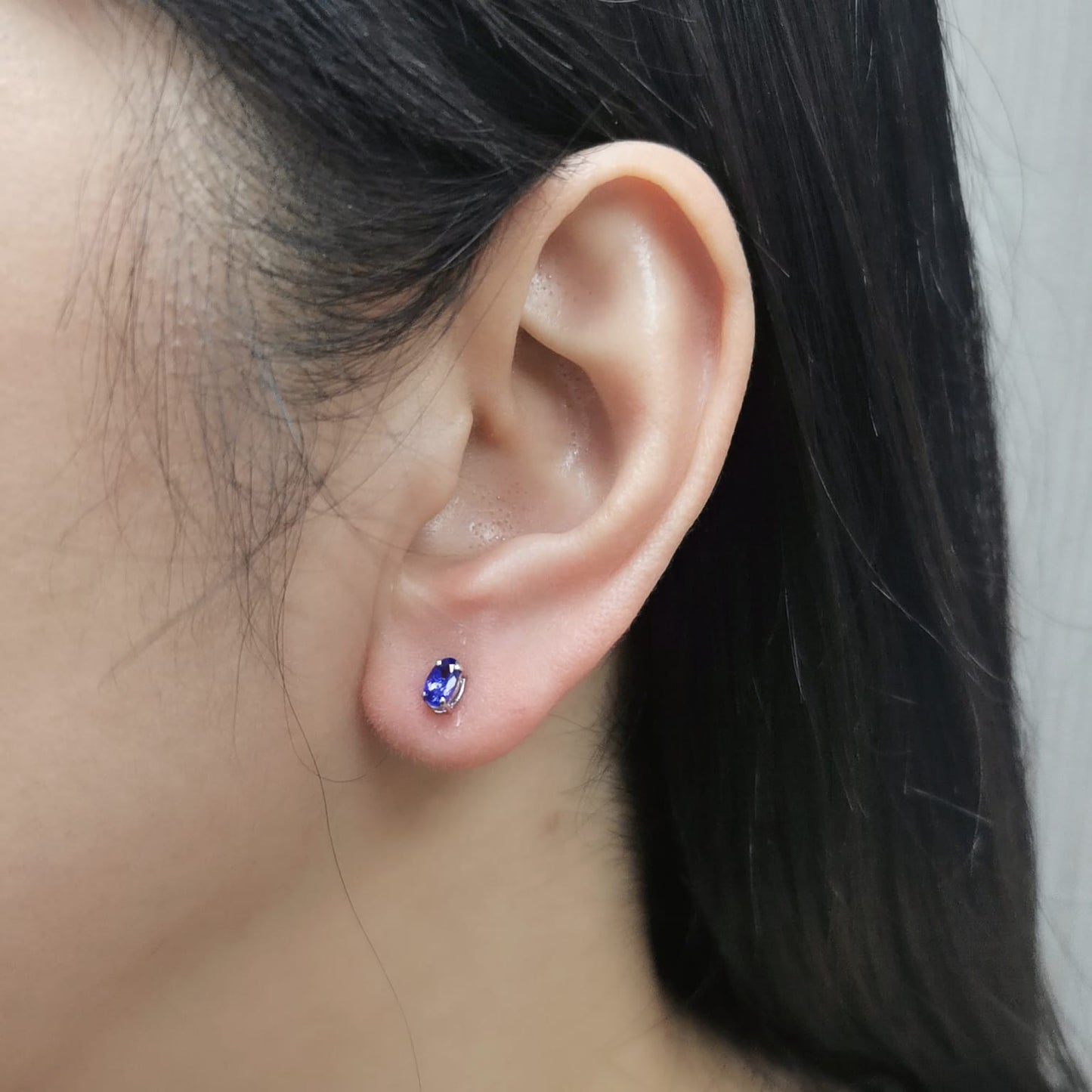18K gold oval Tanzanite earrings featuring 0.62 carats of vibrant December birthstone in a dainty minimalist design – perfect for stacking and everyday wear.