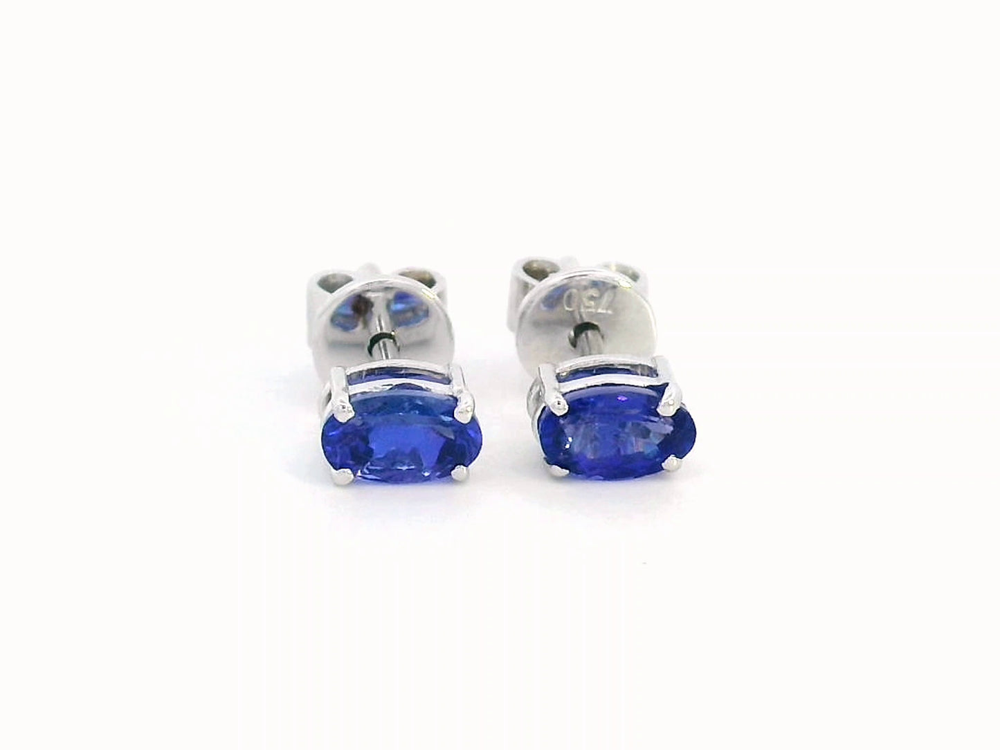 18K gold oval Tanzanite earrings featuring 0.62 carats of vibrant December birthstone in a dainty minimalist design – perfect for stacking and everyday wear.
