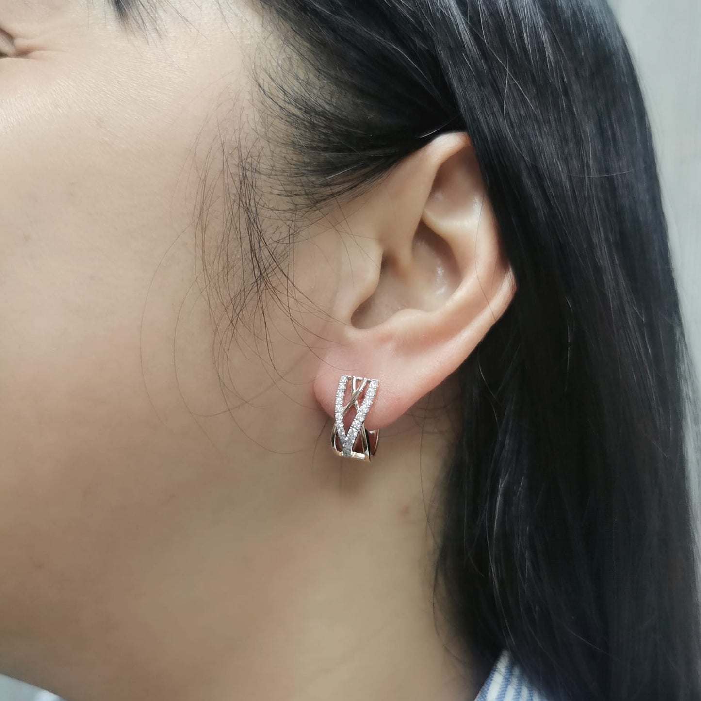 18K gold crisscross diamond huggie earrings, featuring a sleek, contemporary design with 0.52 carats of brilliant diamonds.