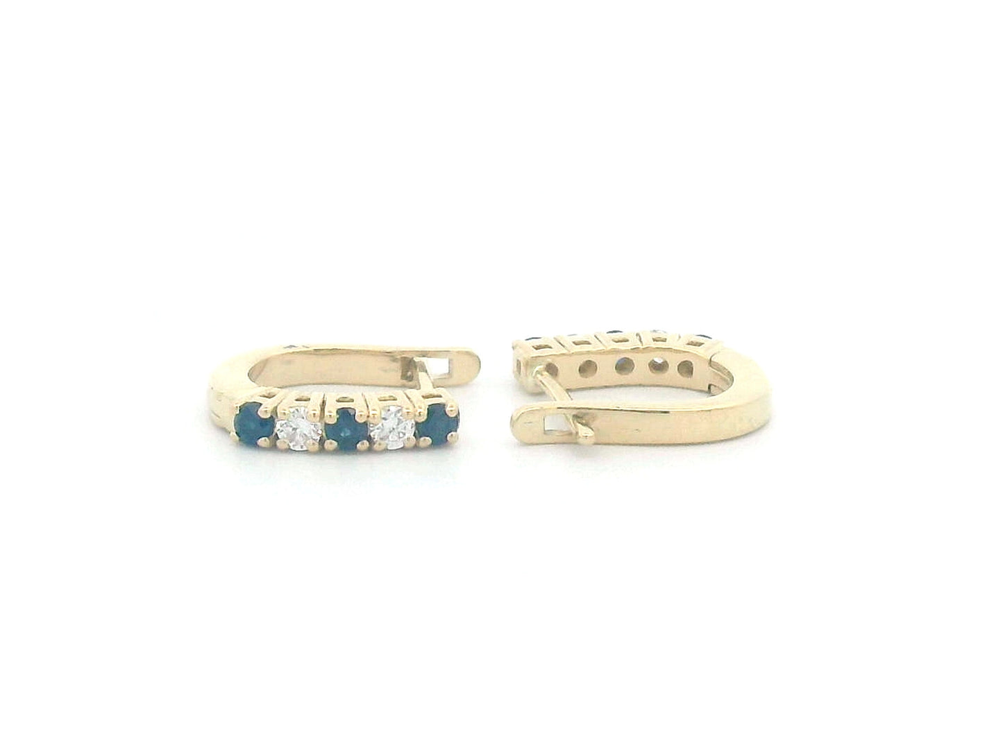 18K gold huggie hoop earrings set with deep blue sapphires and diamonds, offering a refined and elegant look.