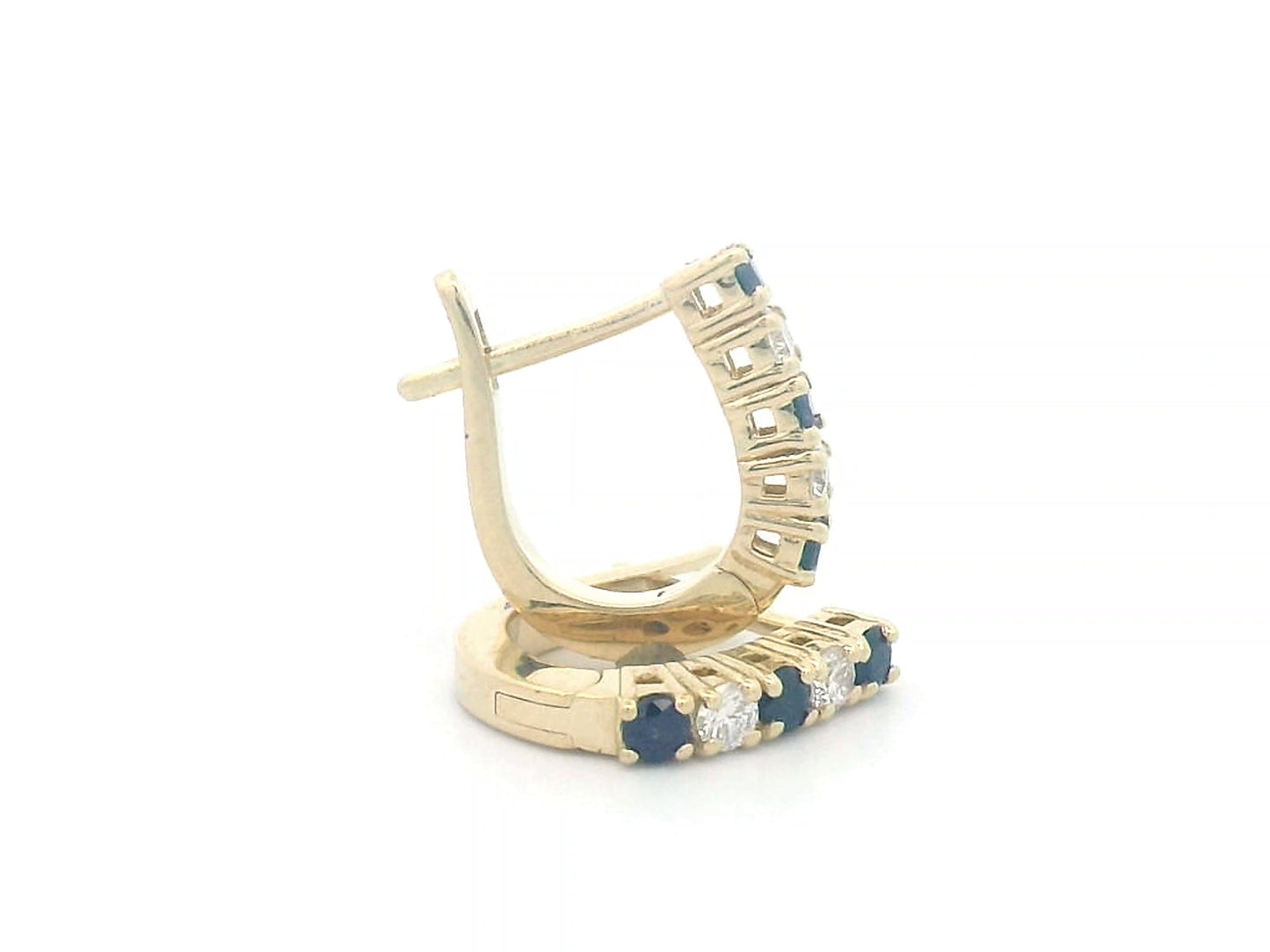 18K gold huggie hoop earrings set with deep blue sapphires and diamonds, offering a refined and elegant look.