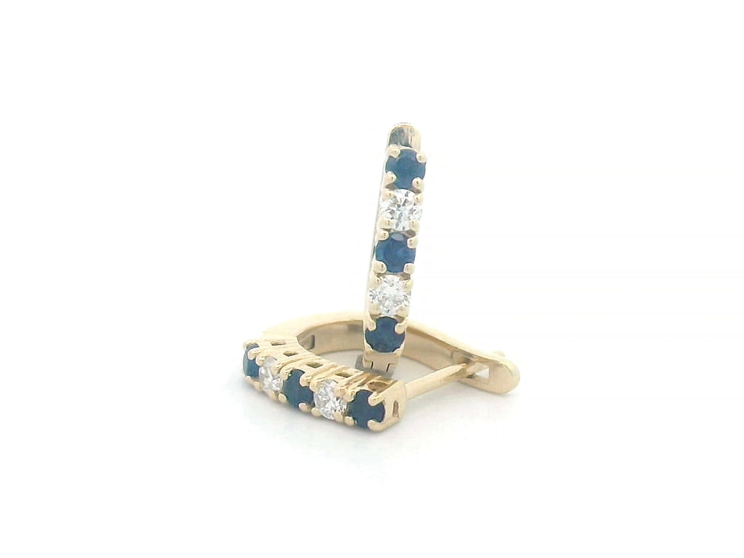 18K gold huggie hoop earrings set with deep blue sapphires and diamonds, offering a refined and elegant look.