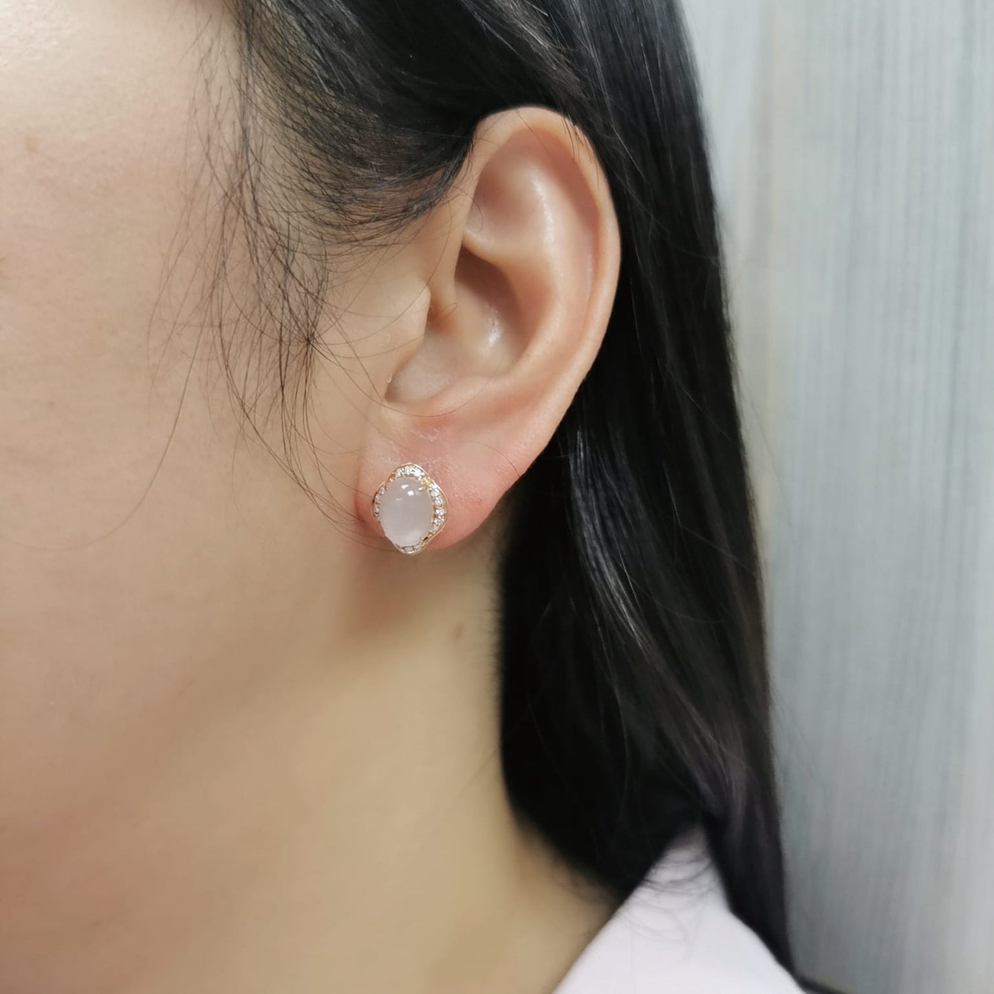 18K rose gold stud earrings with oval-cut rose quartz and a diamond halo.