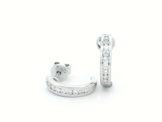 18K gold diamond huggie hoop earrings with channel-set diamonds and butterfly push-back closure.