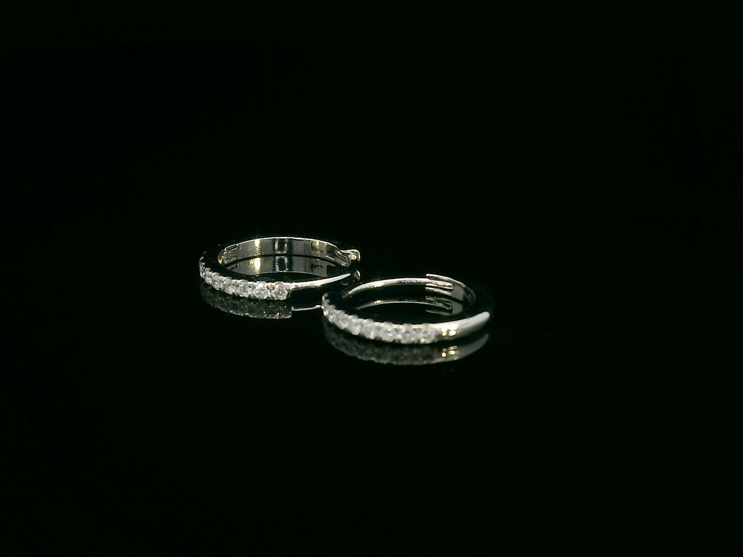 Minimalist 18K gold huggie earrings with 0.10 carat round diamonds in a sleek everyday hoop design