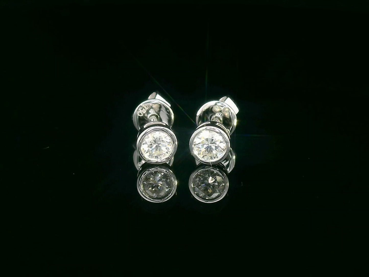 18K white gold bezel set diamond solitaire earrings with 0.32 carat round brilliant diamonds