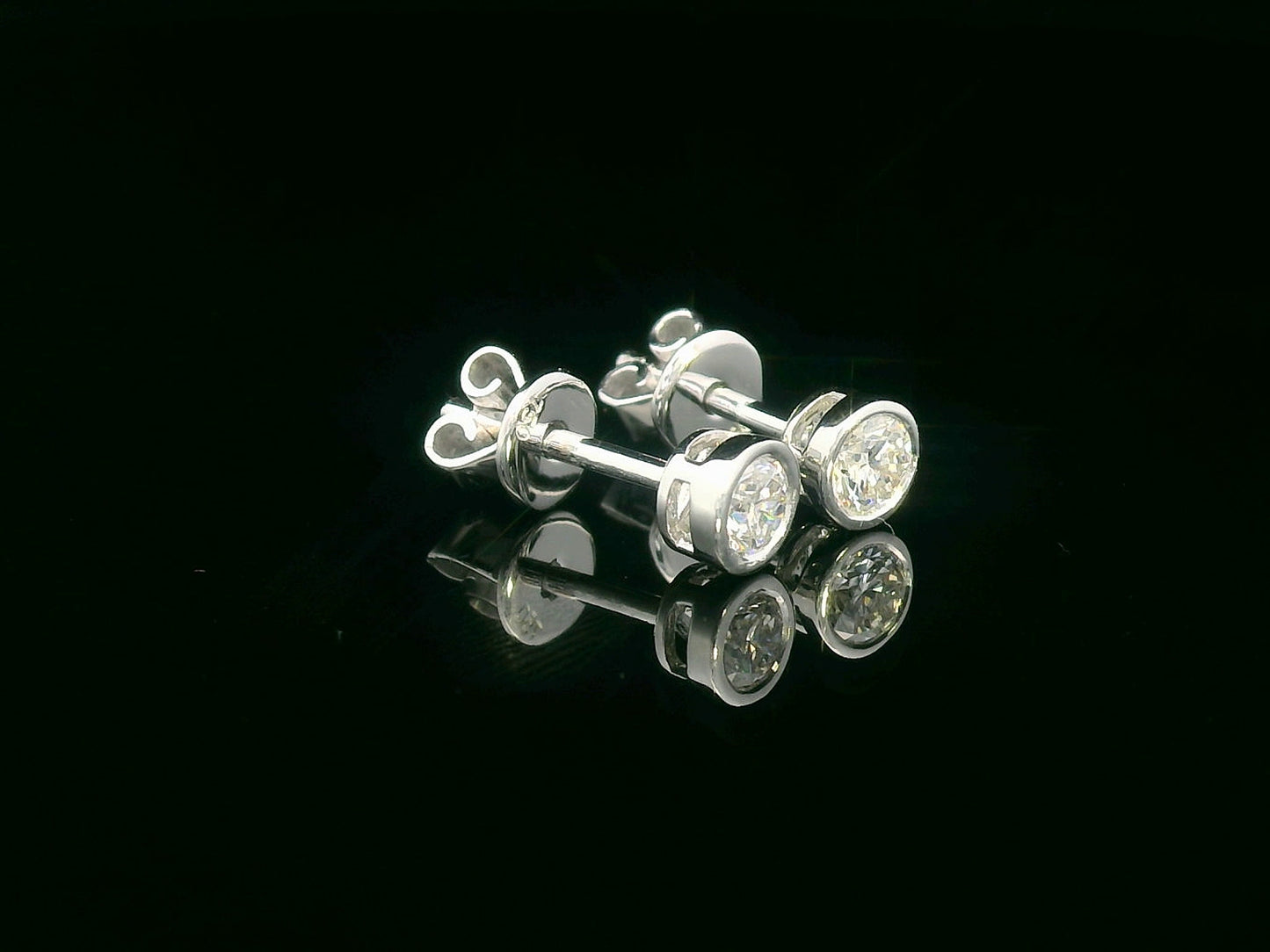 18K white gold bezel set diamond solitaire earrings with 0.32 carat round brilliant diamonds