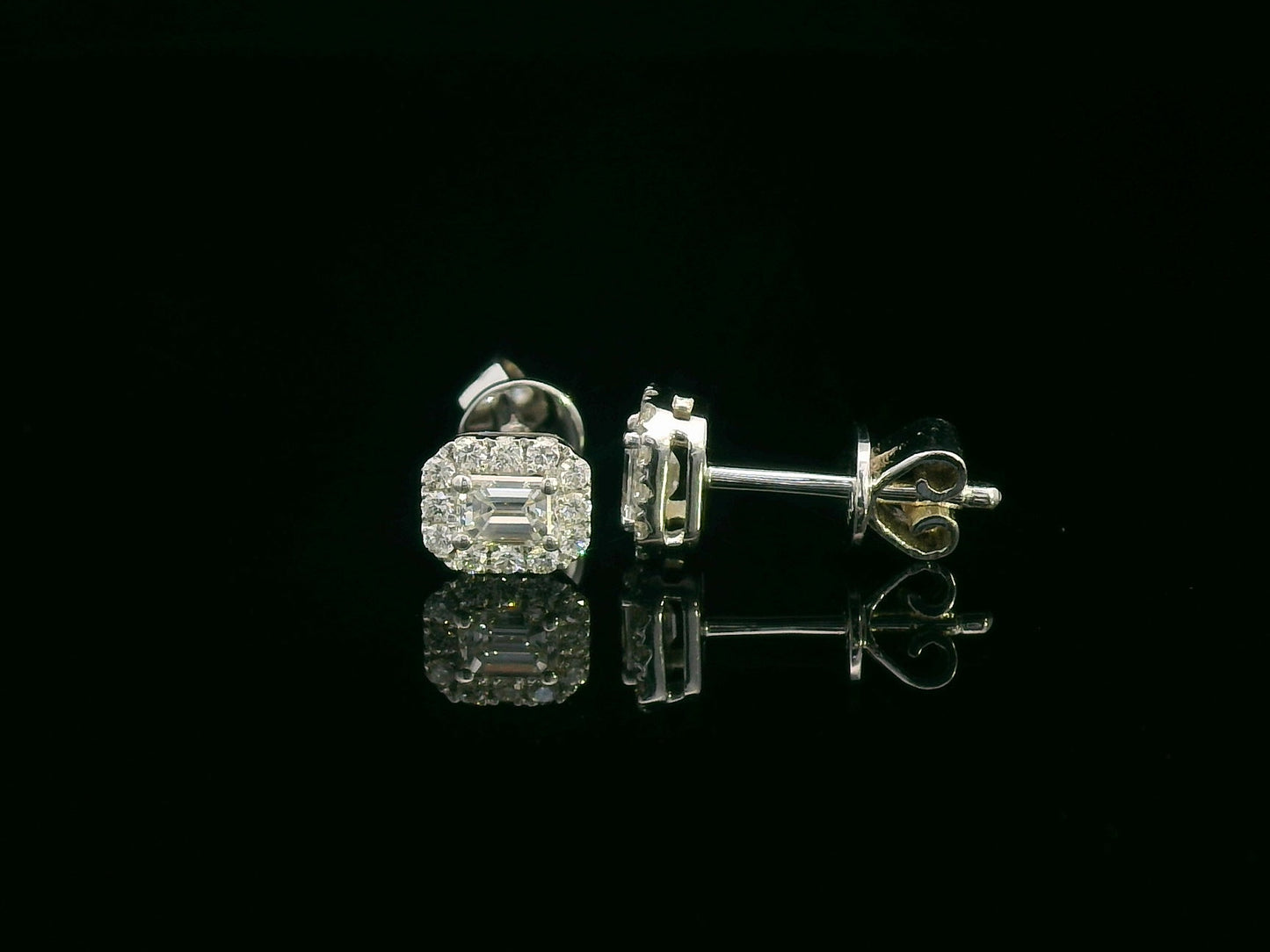 18K gold emerald-cut diamond halo stud earrings with round diamond accents, screw-back style on black background.