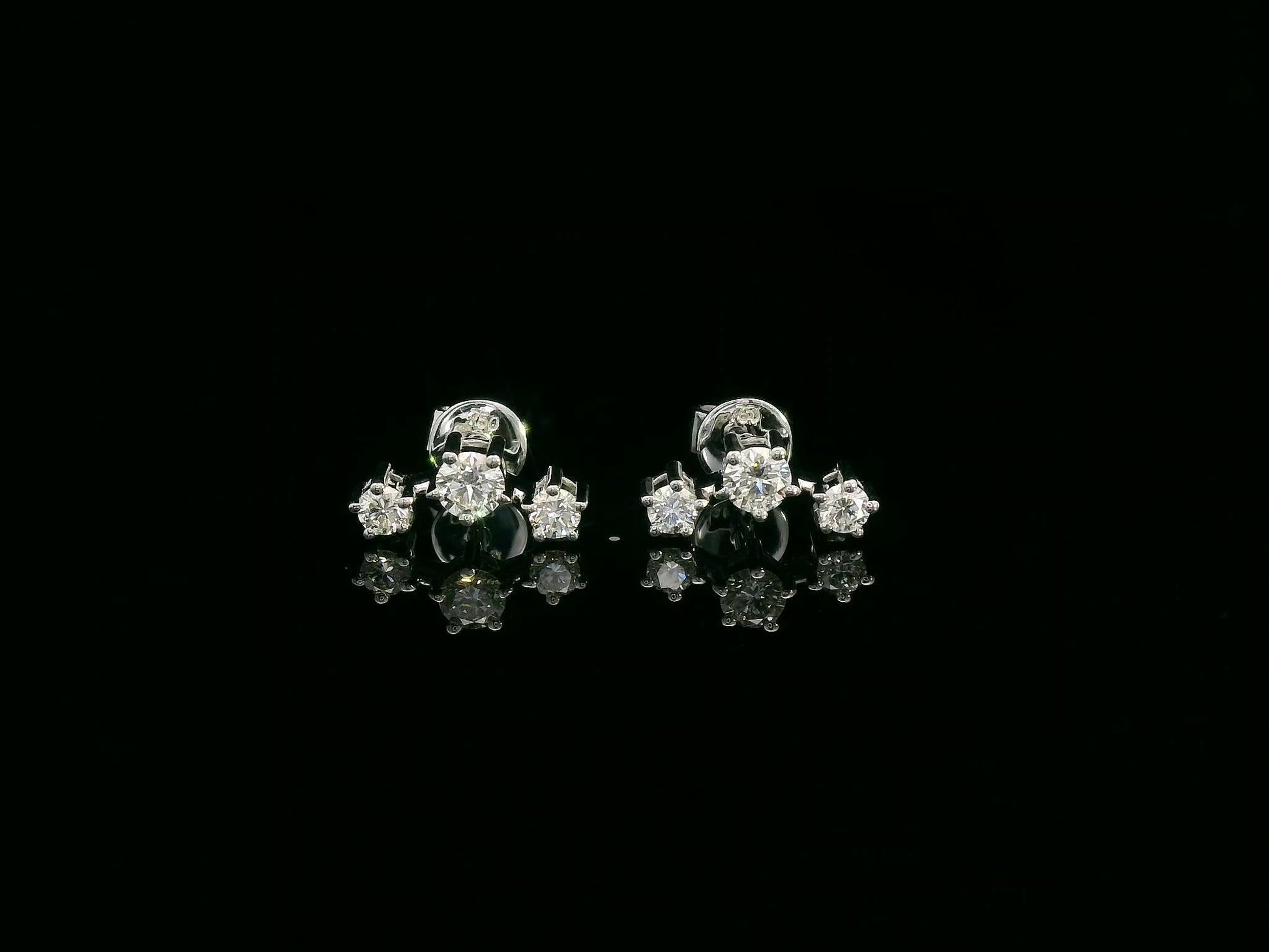 18K gold three-stone diamond stud earrings with graduated round diamonds in a linear design