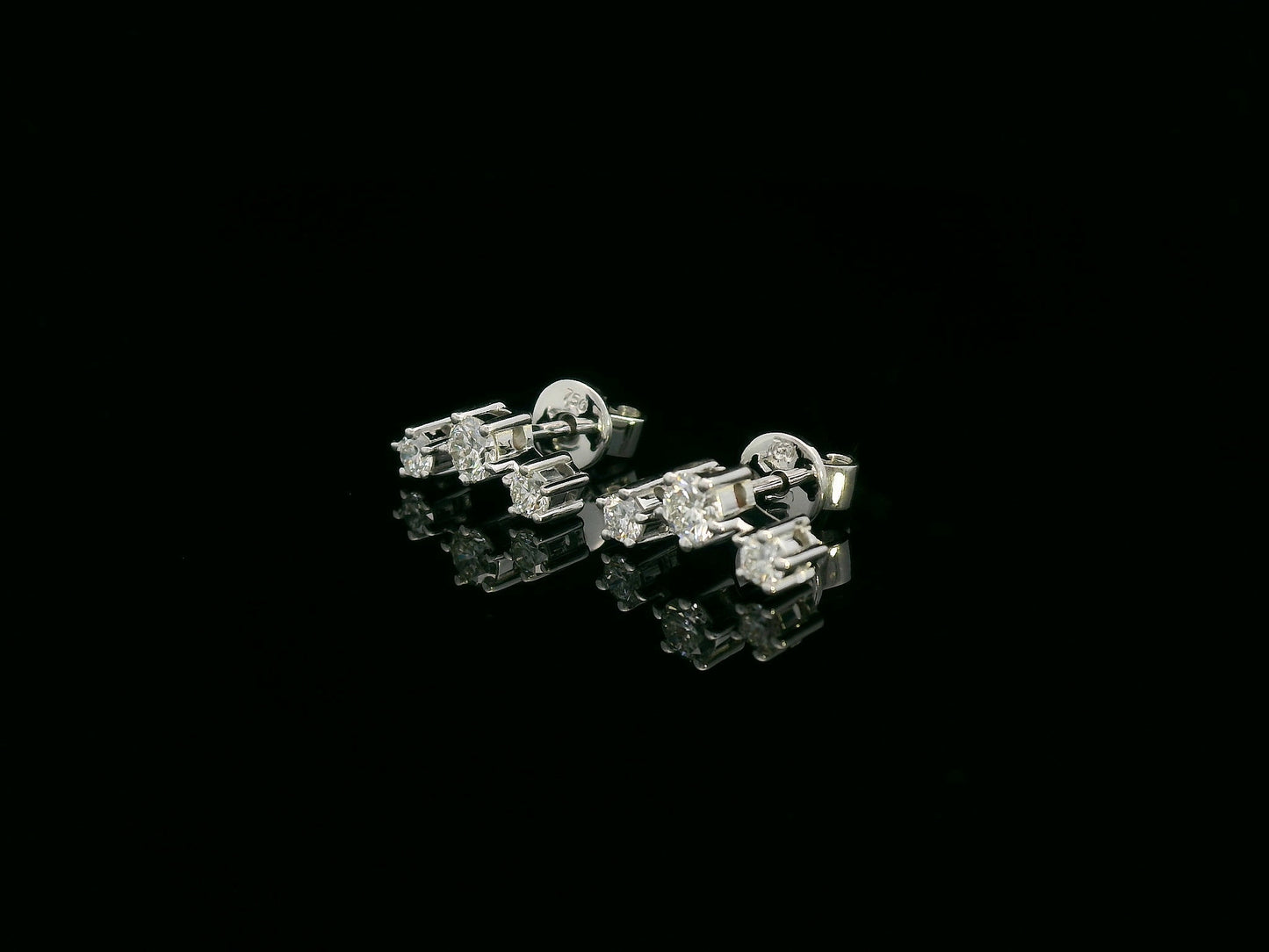 18K gold three-stone diamond stud earrings with graduated round diamonds in a linear design