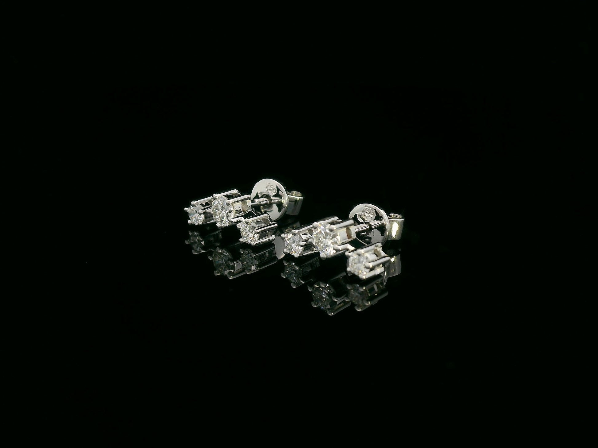 18K gold three-stone diamond stud earrings with graduated round diamonds in a linear design