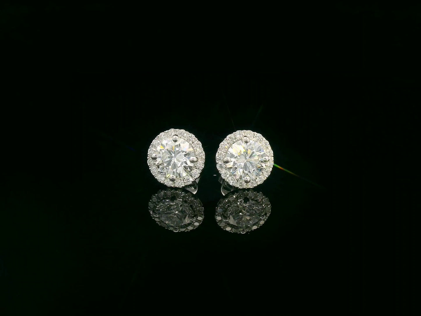 18K white gold diamond stud earrings with 1.01ct and 1.02ct round diamonds and halo totaling 0.33 carats