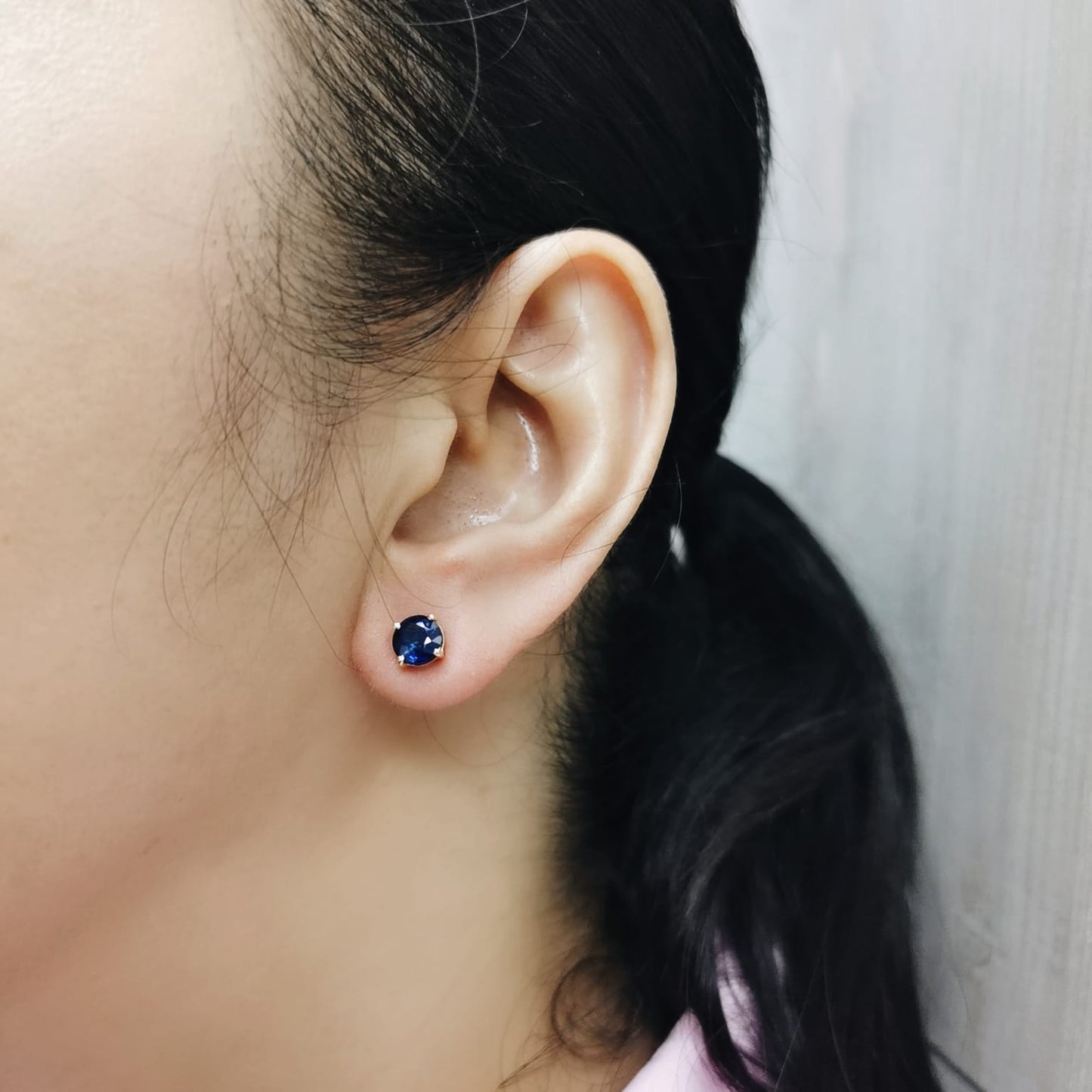 Round cut diffuse blue sapphire solitaire stud earrings in 18K yellow gold with butterfly backs