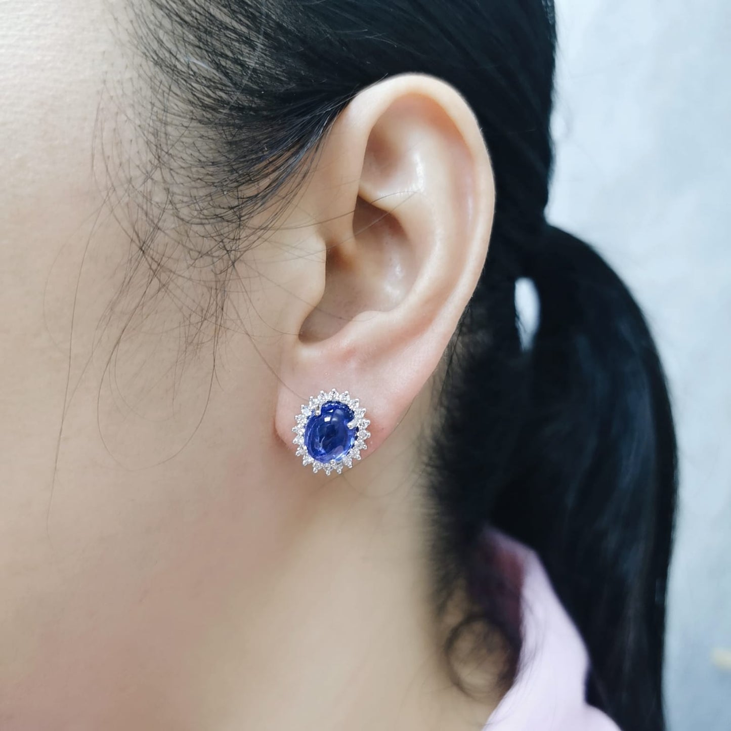 18K gold earrings with oval cabochon Tanzanites and sunburst-style diamond halos totaling 0.70 carats