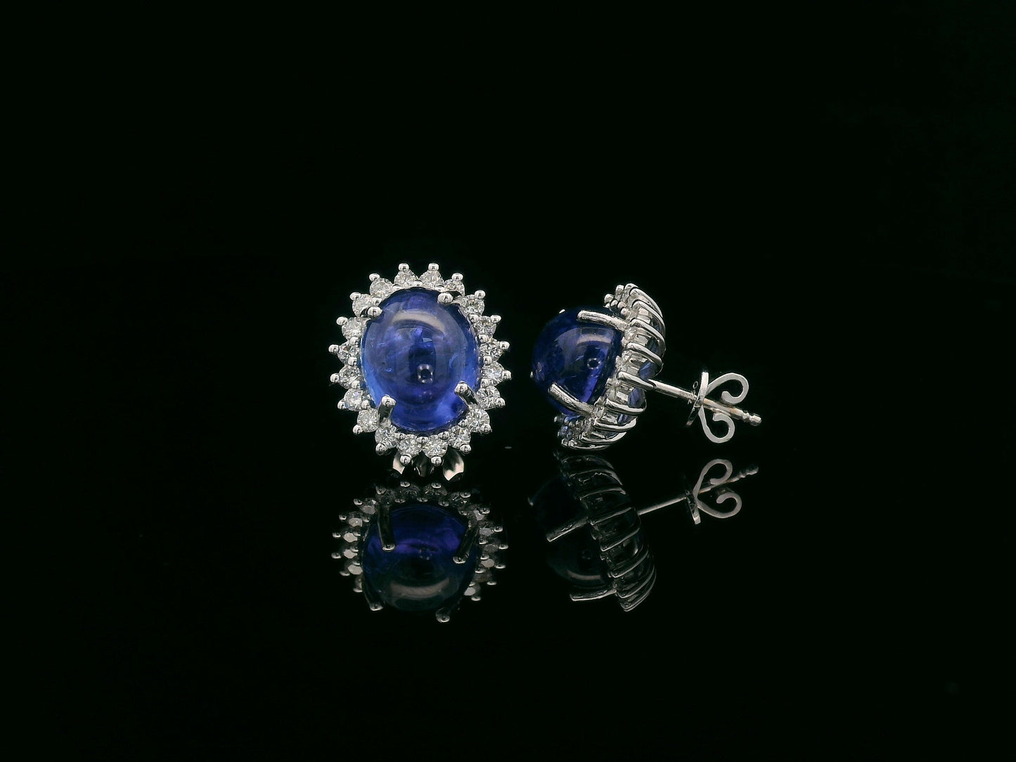 18K gold earrings with oval cabochon Tanzanites and sunburst-style diamond halos totaling 0.70 carats