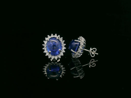 18K gold earrings with oval cabochon Tanzanites and sunburst-style diamond halos totaling 0.70 carats