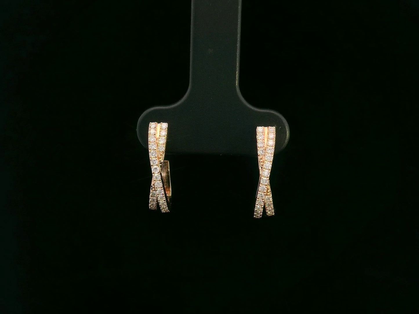 Pair of diamond earrings on a black earring stand