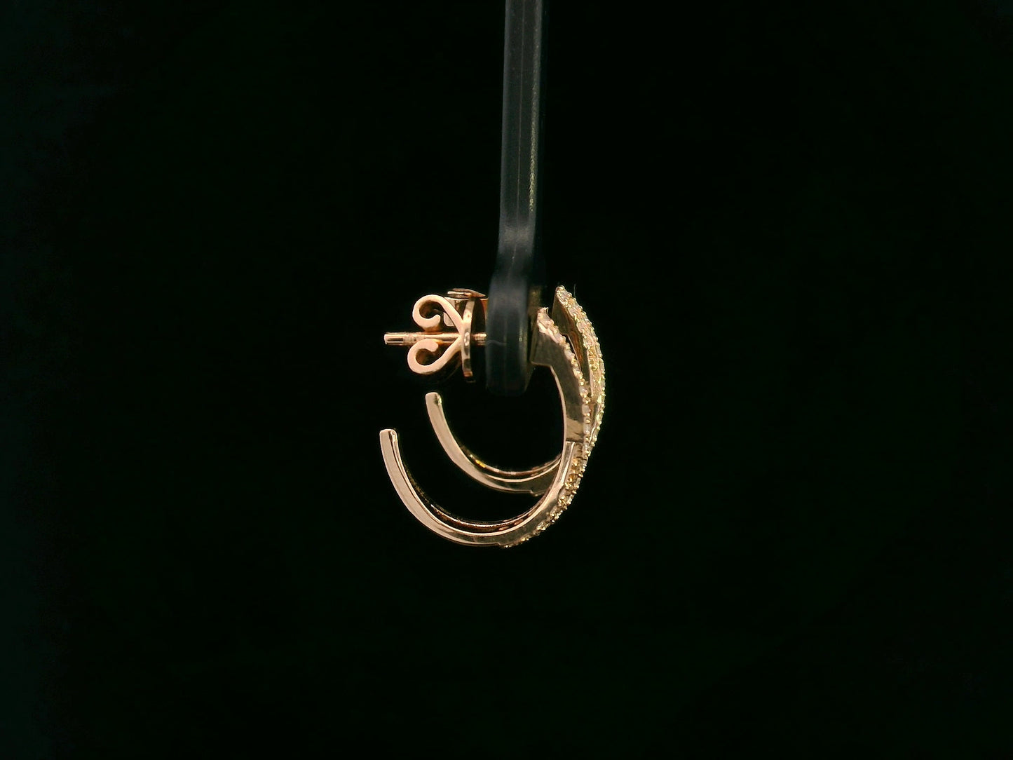 Gold earring on a black background