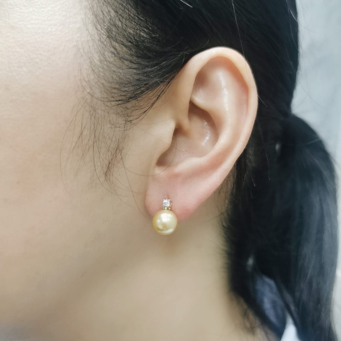 Classic golden pearl earrings topped with sparkling diamonds