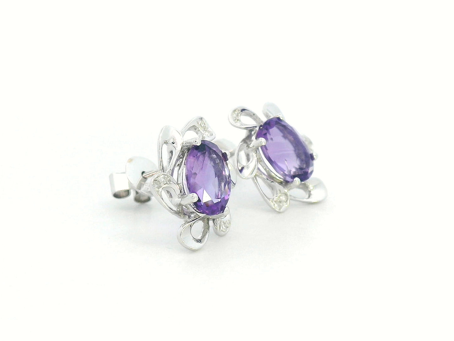 Close-up of 18K gold amethyst and diamond stud earrings on white background