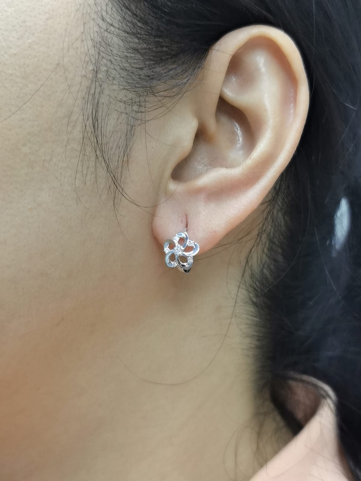 White gold earrings shaped like a flower with diamond accents