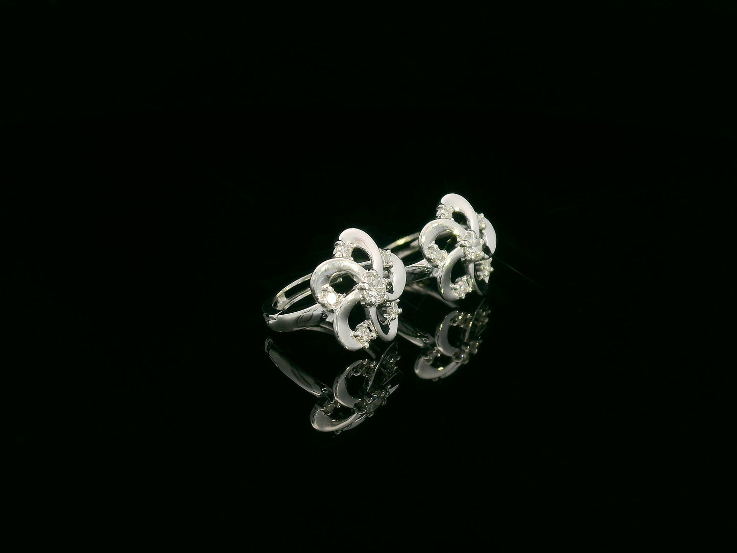 White gold earrings shaped like a flower with diamond accents