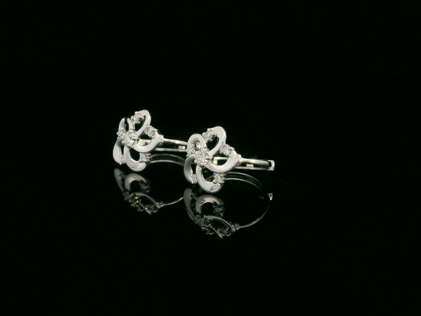 White gold earrings shaped like a flower with diamond accents