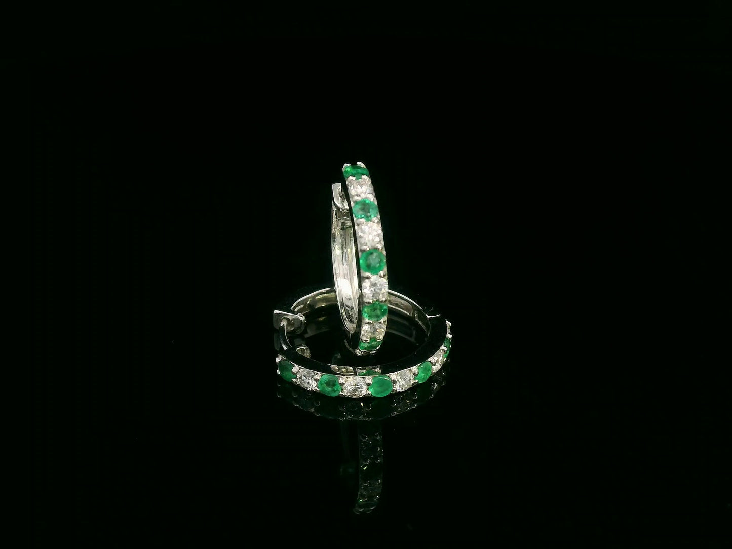 Front view of white gold hoop earrings with sparkling round-cut gemstones
