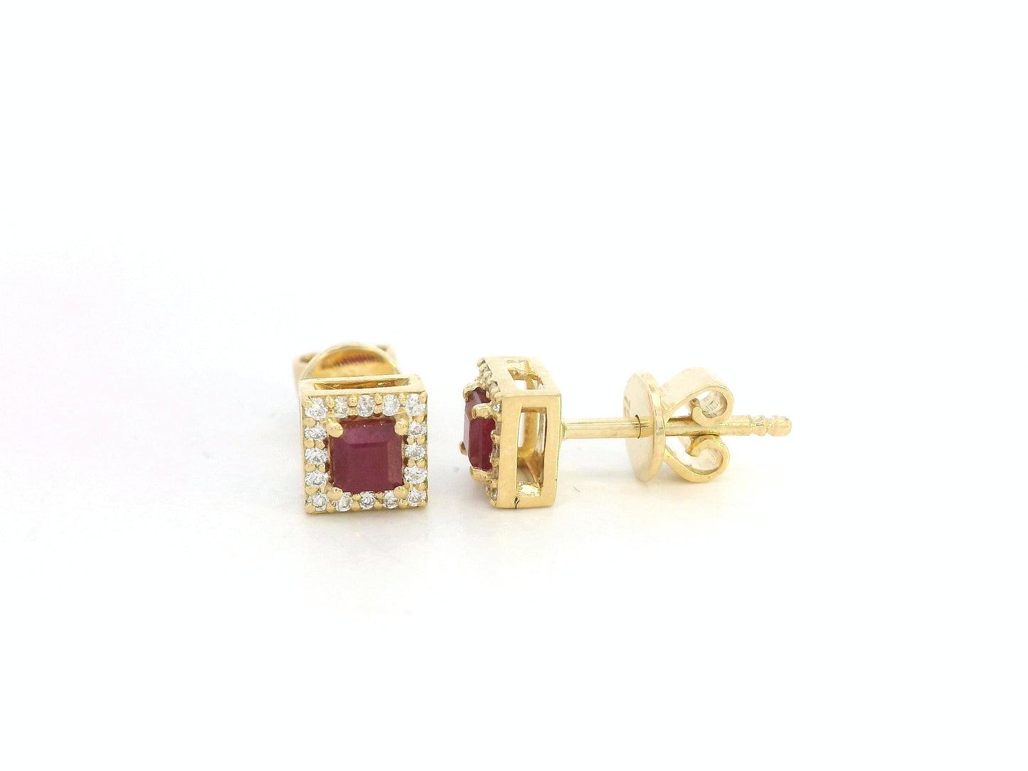 Pair of ruby halo stud earrings with round diamond halos,