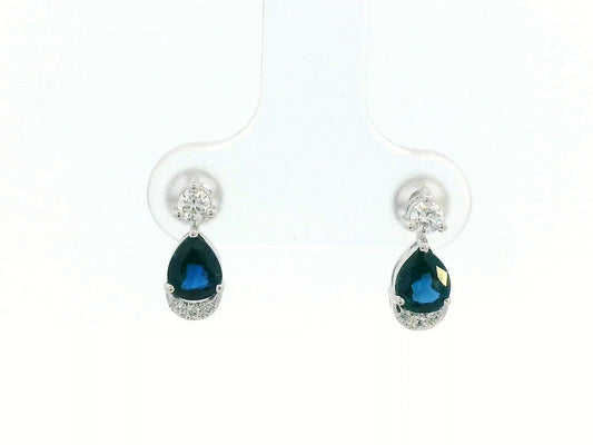 18K white gold drop earrings featuring 0.90ct pear-cut blue sapphires suspended beneath round brilliant diamonds with 0.15ct pavé diamond accent arc.