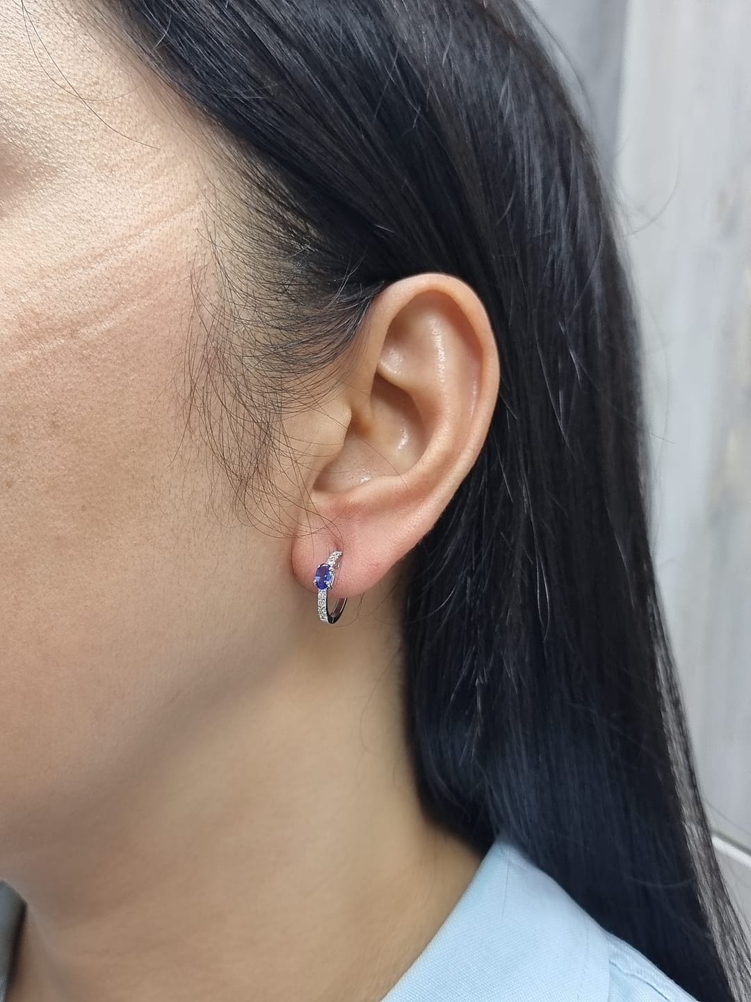 18K white gold hoop earrings featuring 0.44ct oval-cut tanzanites with 0.19ct pavé diamonds along the front curve of each hoop.