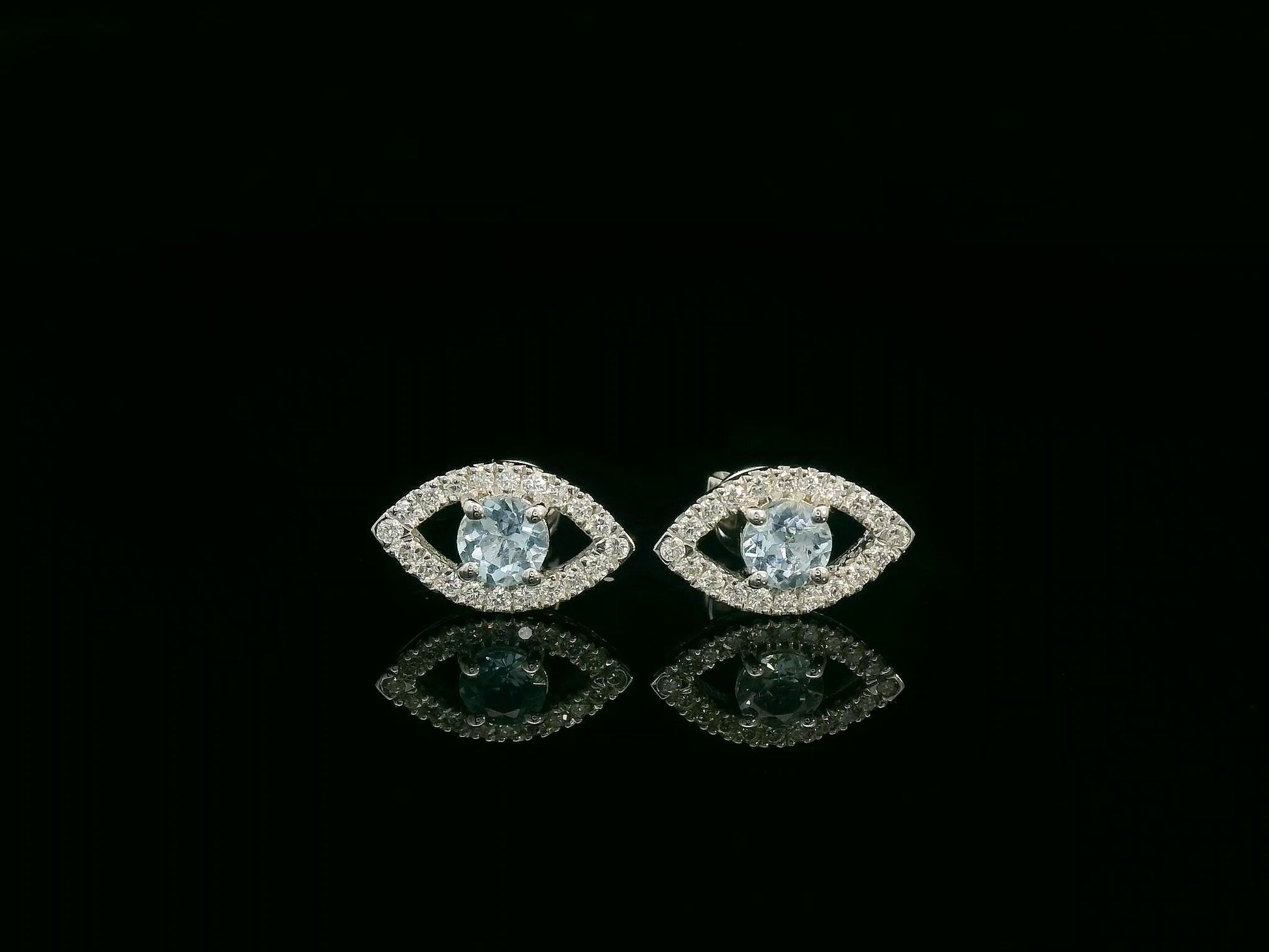 18K white gold evil-eye stud earrings with 0.40ct aquamarine center and 0.23ct pavé diamond halo