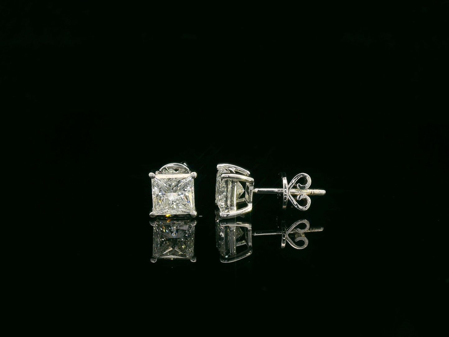 Princess cut diamond solitaire stud earrings in 18K white gold featuring 2.02 carats total GIA certified VS2 F color diamonds by Emirates Diamonds