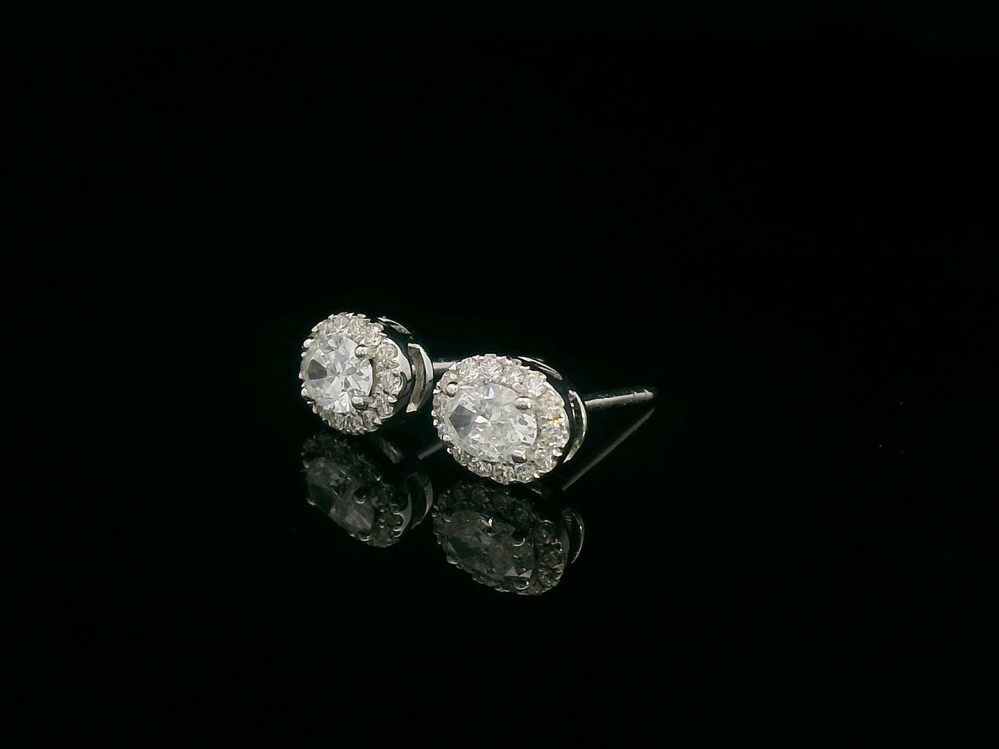 Oval diamond halo stud earrings in 18K white gold with 0.49 carats total diamond weight
