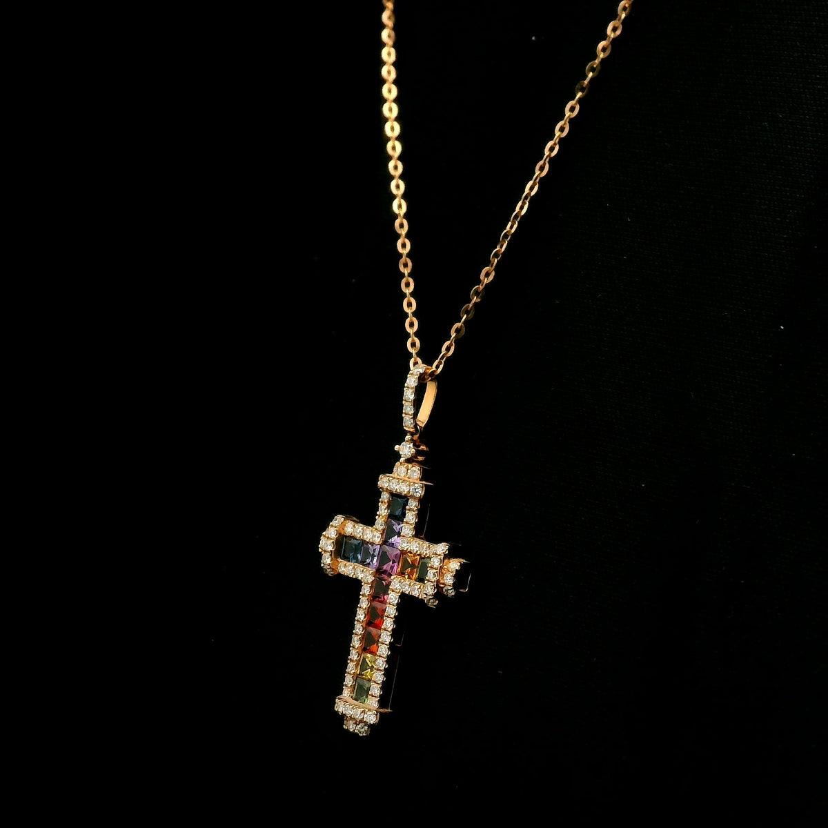Multicolour sapphire and diamond cross necklace in 18K rose gold with colourful sapphires, diamond border and diamond-set bail.